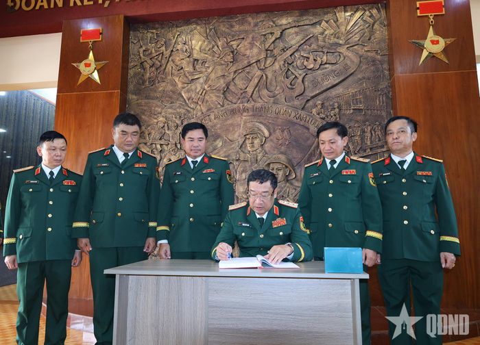 Thượng tướng Phạm Hoài Nam viết sổ lưu niệm tại Nhà truyền thống Sư đoàn 7. 