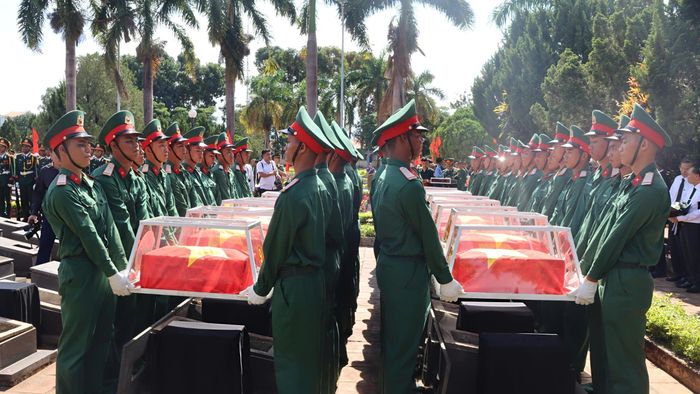 Đưa hài cốt liệt sĩ vào vị trí an táng. Ảnh: HỮU PHÚC