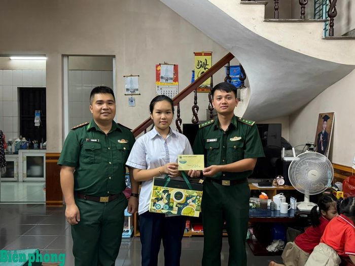 Cháu Nguyễn My Hằng, học sinh lớp 7, Trường Trung học cơ sở Trần Quốc Toản nhận quà Trung thu từ Hải đội Biên phòng 2. Ảnh: Nguyễn Nguyệt