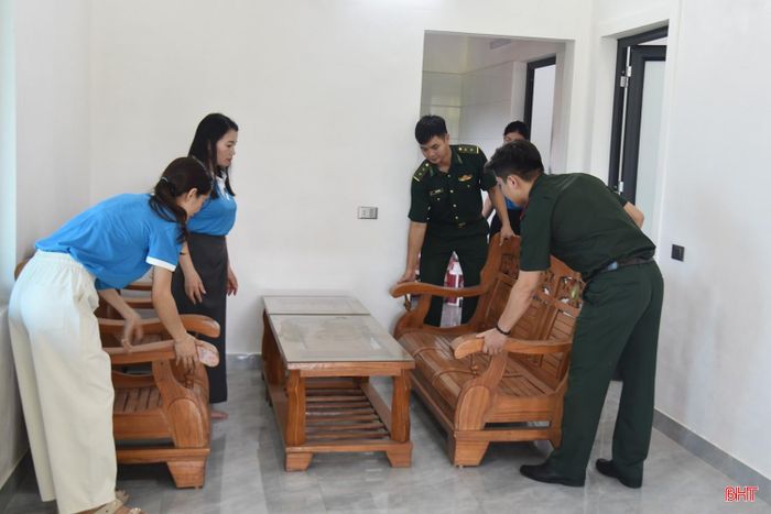 Các lực lượng đến hỗ trợ thân nhân liệt sỹ sắp xếp đồ dùng để chuẩn bị vào nhà mới.