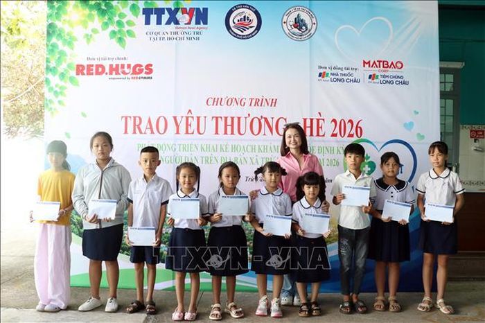 Trao học bổng cho học sinh vượt khó học giỏi tại xã Trừ Văn Thố. Ảnh: Tiến Lực/TTXVN