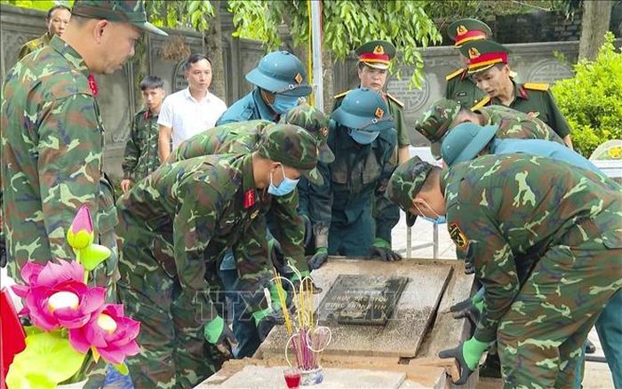 Các lực lượng chức năng phối hợp tháo dỡ phần kết cấu mộ liệt sĩ, thực hiện quy trình khai quật, lấy mẫu hài cốt bảo đảm chặt chẽ, chính xác và trang nghiêm. Ảnh: TTXVN phát