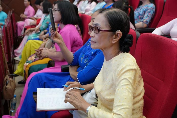 Cô Nguyễn Thị Bé Ba (áo vàng), Trưởng Ban Công tác Mặt trận, Tổ trưởng Tổ phụ nữ khu phố Tân An (phường Tân Đông Hiệp) chăm chú lắng nghe các nội dung tuyên truyền.