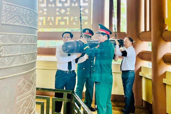 Phó Thủ tướng Hồ Quốc Dũng thực hiện nghi lễ thỉnh chuông khai lễ truy điệu và an táng hài cốt liệt sĩ. Ảnh: Ngọc Minh