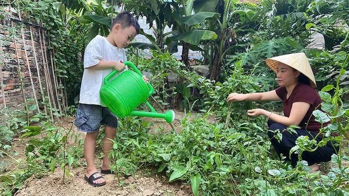Bé Nguyễn Phạm Quang Anh (phường Đông Tiến) được mẹ hướng dẫn chăm sóc cây trong dịp nghỉ hè.