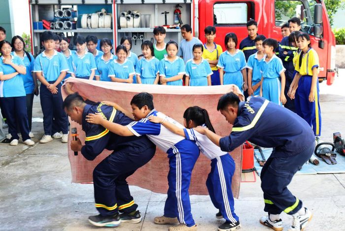 Cán bộ, chiến sĩ Đội Cảnh sát Chữa cháy và Cứu nạn, cứu hộ khu vực Chợ Mới hướng dẫn các em thực hành kỹ năng thoát nạn.