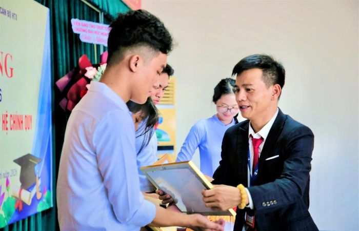 Ông Trần Quang Hậu, Phó Hiệu trưởng phụ trách nhà trường trao thưởng cho học sinh, sinh viên có thành tích học tập tốt năm học 2025 - 2026. Ảnh: ALĂNG NGƯỚC