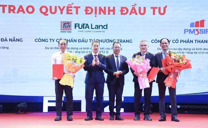 Chủ tịch UBND thành phố Nguyễn Mạnh Hùng (thứ 2, bên trái sang) và Trưởng ban Quản lý Khu công nghệ cao và các khu công nghiệp Đà Nẵng Vũ Quang Hùng (giữa) trao quyết định chấp thuận chủ trương đầu tư vào các khu chức năng vị trí số 2, số 3 và số 4 thuộc FTZ Đà Nẵng cho 3 doanh nghiệp. Ảnh: NGỌC PHÚ