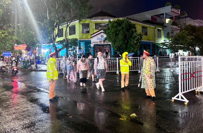 Lực lượng Cảnh sát Giao thông đội mưa giữ trật tự quanh khu vực khán đài chính. Ảnh: KHÁNH NGÂN
