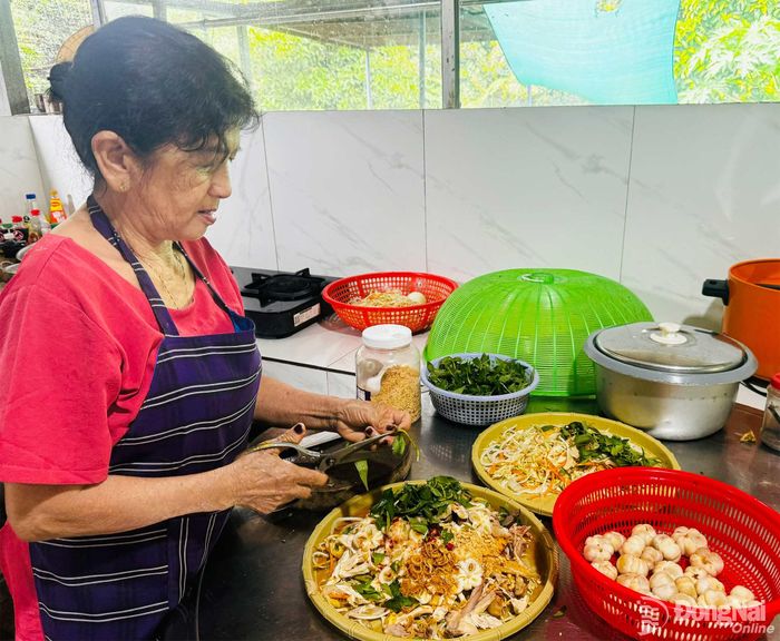 Bà Võ Thị Hồng, đầu bếp chính của vườn cây ăn trái Út Tiêu (phường Bình Lộc) chế biến món gỏi gà măng cụt.