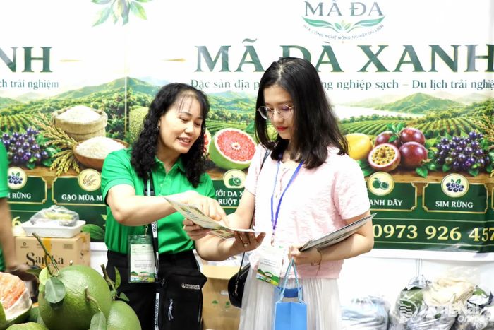 Bà Đinh Thị Nga (trái) đại diện Hợp tác xã Công nghệ nông nghiệp du lịch Mã Đà Xanh (phường Trị An, thành phố Đồng Nai) giới thiệu thông tin sản phẩm cho khách hàng.