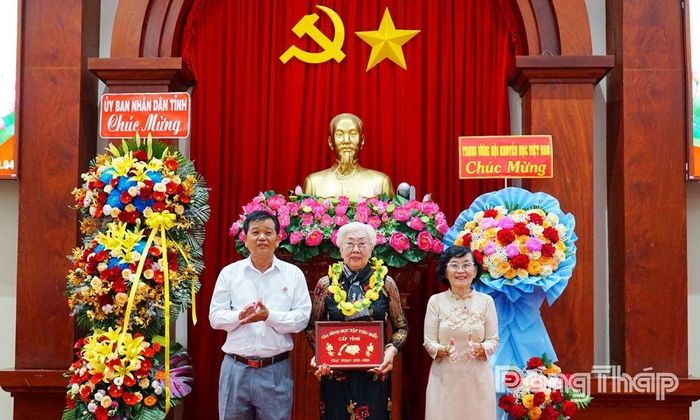  Bà Nguyễn Thị Trị được trao biểu trưng và vòng hoa tuyên dương ở mô hình “Gia đình học tập tiêu biểu”.