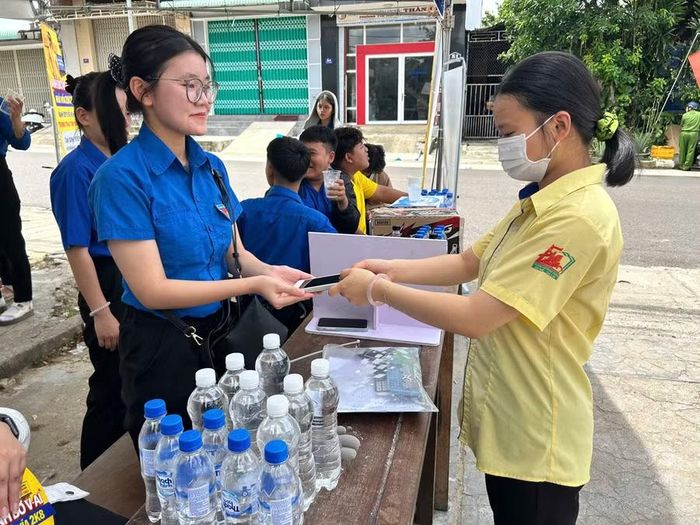 Thí sinh gửi điện thoại cho lực lượng đoàn viên, thanh niên trước khi vào phòng thi tại điểm thi Trường THPT số 2 Quang Trung (phường An Khê). Ảnh: Minh Chí