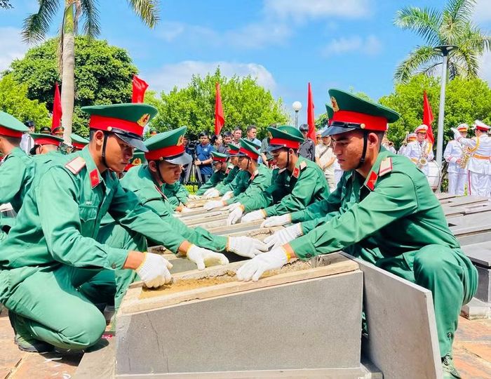  Các chiến sĩ thực hiện nghi lễ rải cát lên phần mộ trước khi an táng. Ảnh: P.D 