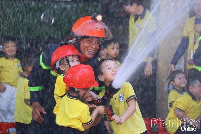 Thích thú khi được phun nước chữa cháy cùng chiến sĩ chữa cháy.