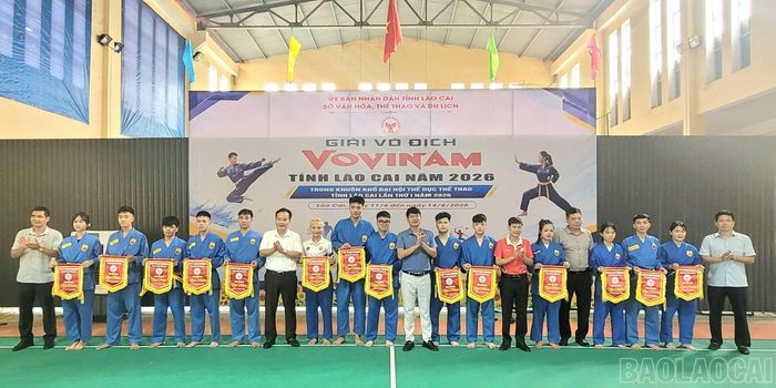 Ban tổ chức trao cờ lưu niệm cho các đoàn tham dự Giải vô địch Vovinam tỉnh Lào Cai năm 2026.