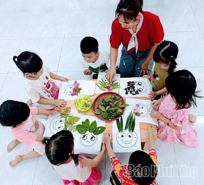 Các bạn nhỏ Trường mầm non Lâm Thao trang trí cho bức tranh bằng hoa, lá.