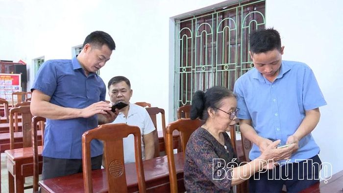 Cán bộ Trung tâm Phục vụ hành chính công xã Hạ Hòa hỗ trợ người dân Khu 1 tiếp cận các dịch vụ công trên điện thoại di động.