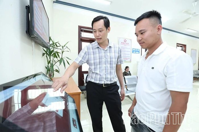 Cán bộ Trung tâm Phục vụ hành chính công xã Hạ Hòa hướng dẫn người dân thực hiện các thủ tục hành chính trên môi trường số.