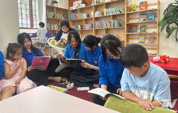 Các bạn trẻ đọc sách cùng thiếu nhi tại phòng đọc của Thư viện.