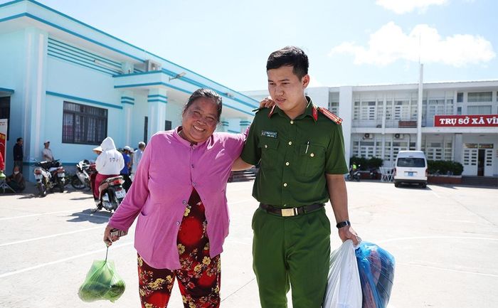 Lực lượng Công an hỗ trợ người dân đến nhận quà. Ảnh: Tiến Tầm