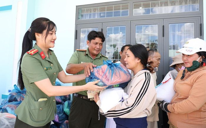 Đại diện Ban Phụ nữ Công an tỉnh, Công an xã Vĩnh Thuận trao tặng quà đến người dân. Ảnh: Tiến Tầm
