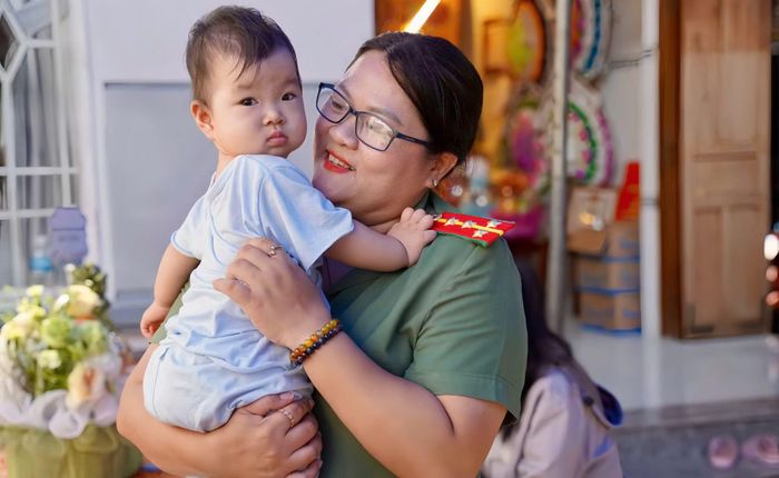 Đại úy Nguyễn Thu Kỳ Thảo, Trưởng Ban Phụ nữ Công an tỉnh Khánh Hòa bồng bế cháu Nguyễn Lê Hải Yến - con gái của Thiếu tá Nguyễn Xuân Hải, cán bộ Công an xã Diên Lâm, dũng cảm hy sinh trong khi thi hành công vụ.