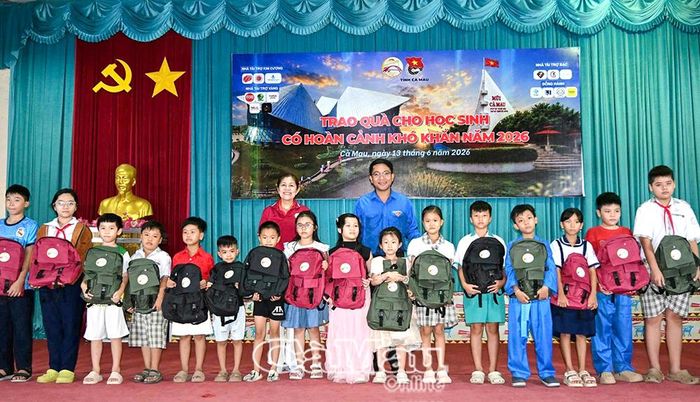  Phó Bí thư Thường trực Tỉnh đoàn Cà Mau Trần Đăng Khoa cùng đại diện nhà tài trợ trao quà cho các em học sinh.