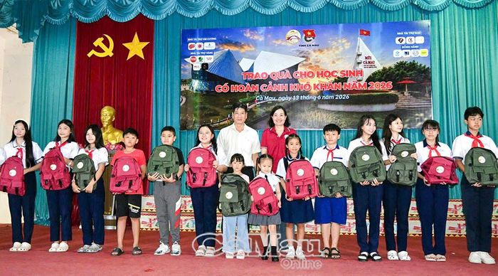 Ông Đặng Trí Thủ, Phó Giám đốc Sở Giáo dục và Đào tạo tỉnh Cà Mau và bà Lê Thị Ngọc, Phó Chủ tịch Hội Doanh nghiệp Bình Lợi Trung, trao quà cho học sinh có hoàn cảnh khó khăn.