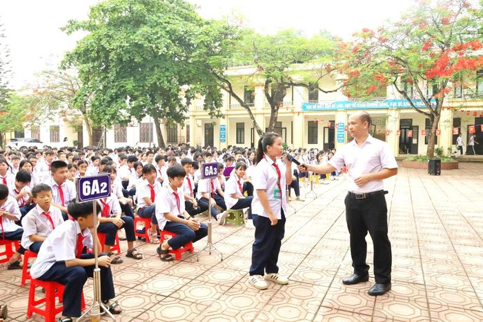 Cán bộ Trung tâm Trợ giúp pháp lý nhà nước đưa ra câu hỏi cho các học sinh tại phiên tòa giả định được tổ chức tại trường THCS Xuân Sơn, phường Tùng Thiện, TP Hà Nội. Ảnh: Thu Ngân