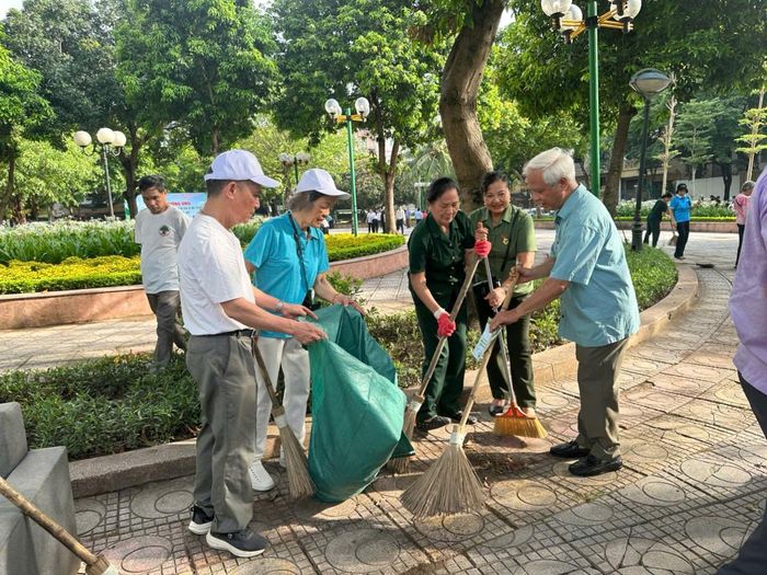 Chủ tịch Hội Người cao tuổi thành phố Nguyễn Thế Toàn (phải) cùng hội viên tham gia thu gom rác. Ảnh: Bảo Lâm
