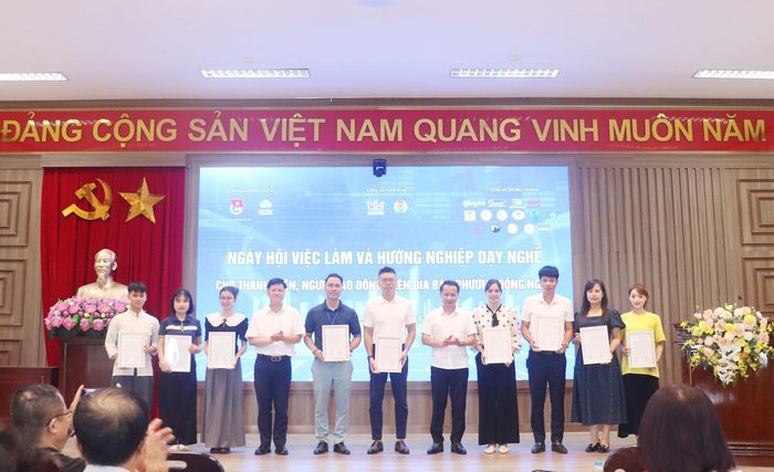 Phó Bí thư Thường trực Đảng ủy phường Đông Ngạc Dương Ngọc Thanh cùng đại diện lãnh đạo Trung tâm Dịch vụ việc làm và Hỗ trợ Thanh thiếu niên Hà Nội trao thư cảm ơn các đơn vị phối hợp tổ chức ngày hội. Ảnh: Trần Thảo