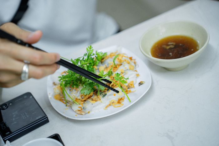  Thực khách thưởng thức bánh cuốn thịt kèm nước chấm. 