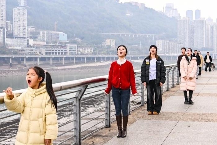 Du khách há miệng chờ "nuốt" đoàn tàu tại công viên Binjiang, quận Giang Bắc, thành phố Trùng Khánh, Trung Quốc, vào ngày 15/2/2025. Ảnh: Qi Lansen.
