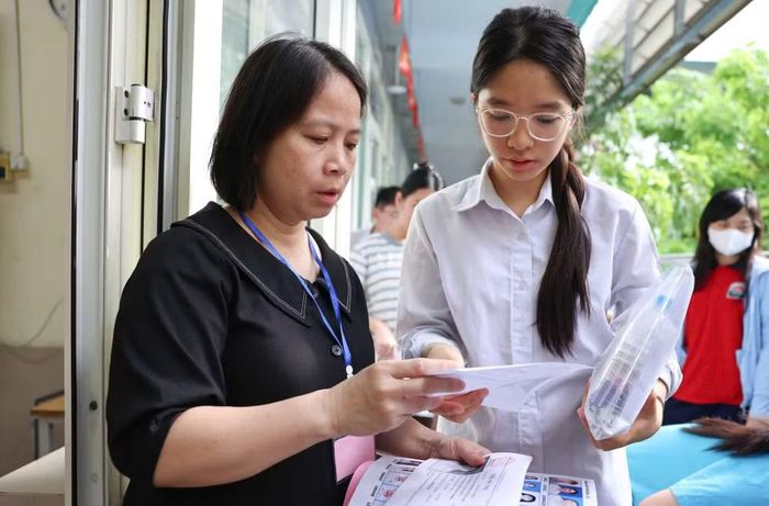  Kiểm tra thông tin trước khi thí sinh vào phòng thi. (Ảnh: ĐẠI THẮNG) 