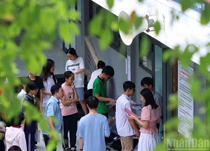 Giám thị kiểm tra thông tin thí sinh trước khi vào phòng thi sáng 14/6.