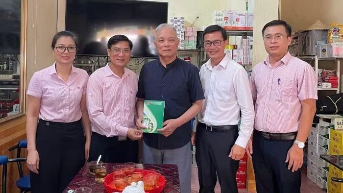 Các cán bộ NHCSXH tỉnh Cao Bằng tặng quà cho những hộ dân gặp khó khăn do bị ảnh hưởng bão lũ.
