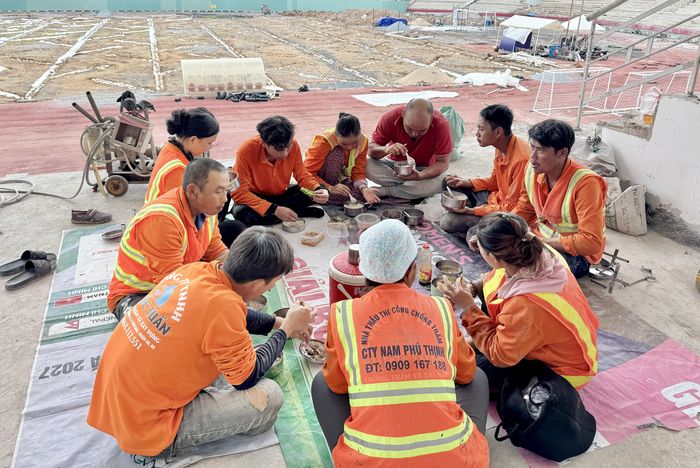 Các công nhân tranh thủ dùng bữa trưa ngay tại công trường