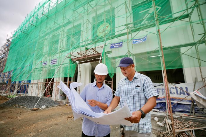 Ông Hoàng Ngọc Tuấn (phải), Phó Giám đốc Trung tâm TDTT Thống Nhất, đơn vị quản lý sân vận động Thống Nhất theo dõi tiến trình sửa chữa và màu sơn của mặt trước sân