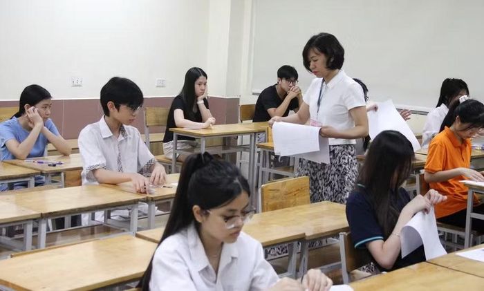 Giám thị phát giấy thi cho thí sinh.