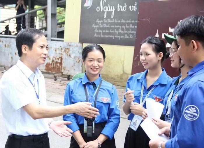 TS Phạm Sĩ Cường - Hiệu trưởng Trường THCS & THPT Nguyễn Tất Thành trao đổi, động viên lực lượng sinh viên tình nguyện hỗ trợ kỳ thi tuyển sinh vào lớp 10 của nhà trường.