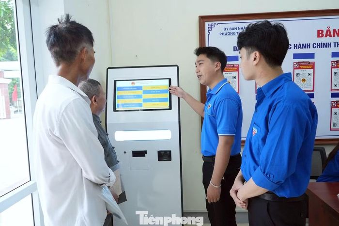 Đoàn viên thanh niên phường Trường Vinh hướng dẫn người dân lấy số thứ tự tại Trung tâm Phục vụ hành chính công.