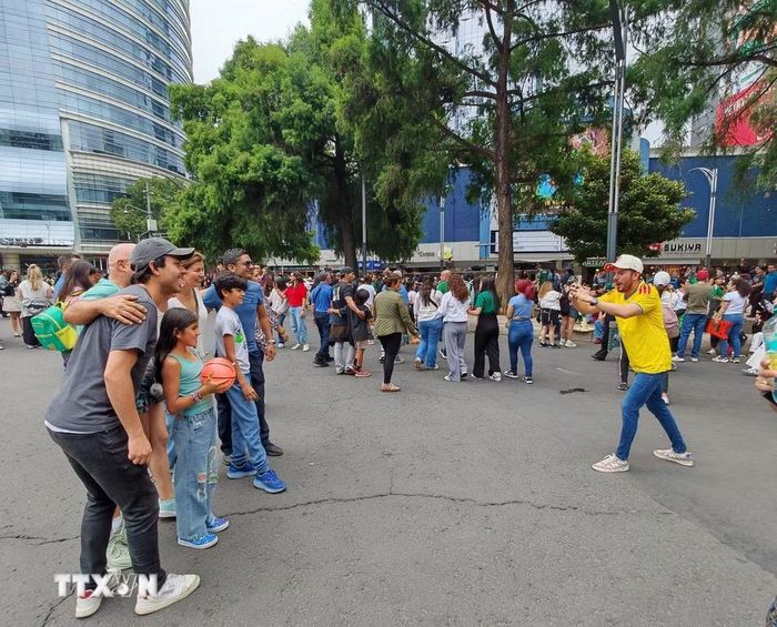 Du khách quốc tế chụp ảnh lưu niệm tại cuộc diễu hành văn hóa chào mừng World Cup 2026 ở Mexico City ngày 13/6. (Ảnh: Phương Lan/TTXVN)