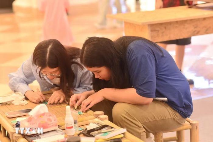 Các bạn trẻ trải nghiệm workshop tại "Chợ phiên kết duyên sáng tạo". (Ảnh: Hà Linh/TTXVN phát)