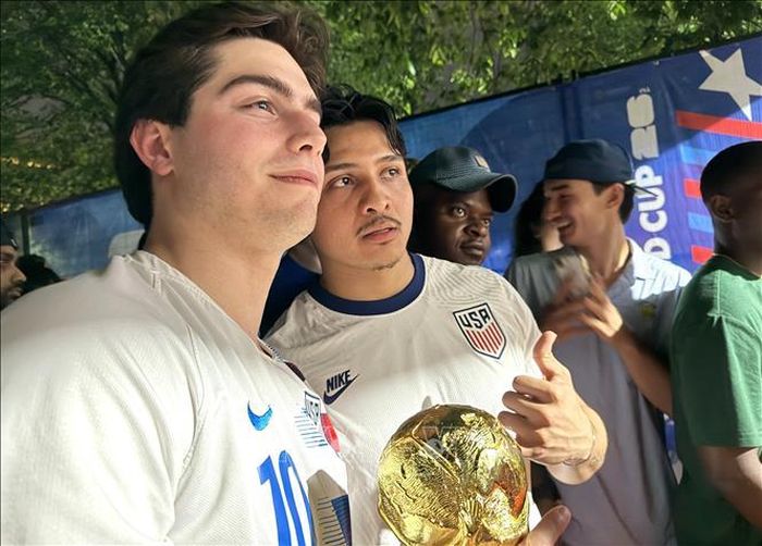 Cổ động viên Mỹ hào hứng cầm mô hình Cúp Vàng FIFA World Cup tại khu Fan Zone. Ảnh: Ngọc Quang/PV TTXVN tại Mỹ