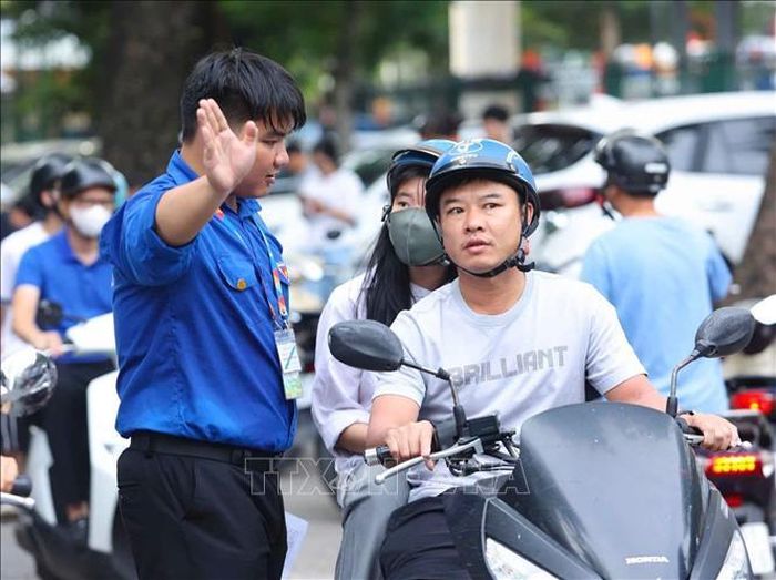 Các tình nguyện viên hướng dẫn phụ huynh và thí sinh vào khu vực thi. Ảnh: Bùi Tiến Long/TTXVN phát