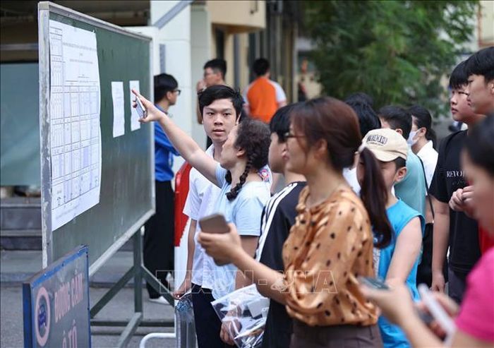 Phụ huynh cùng thí sinh xem sơ đồ bố trí phòng thi. Ảnh: Thanh Tùng/TTXVN
