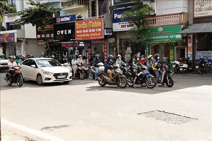 Các phương tiện đứng chờ đèn đỏ dưới bóng râm để tránh nắng nóng. Ảnh: Vũ Quang/TTXVN