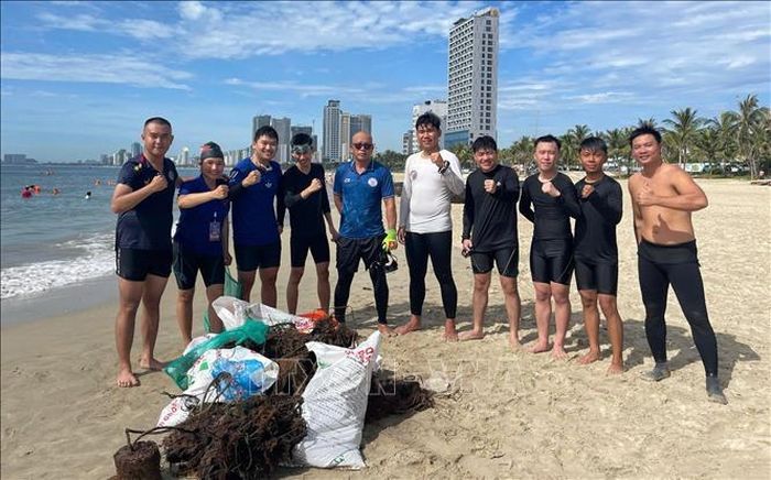 Các tình nguyện viên lặn biển vớt rác hào hứng khi thu gom lưới cũ, rác thải mắc vào rạng san hô ở biển để giúp san hô phát triển. Ảnh: TTXVN phát