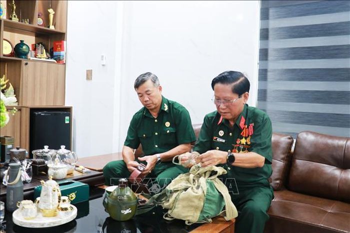 Cựu chiến binh Đoàn Xuân Luyến (phải) trân quý những kỷ vật của một thời chiến đấu oanh liệt tại chiến trường Quảng Trị.